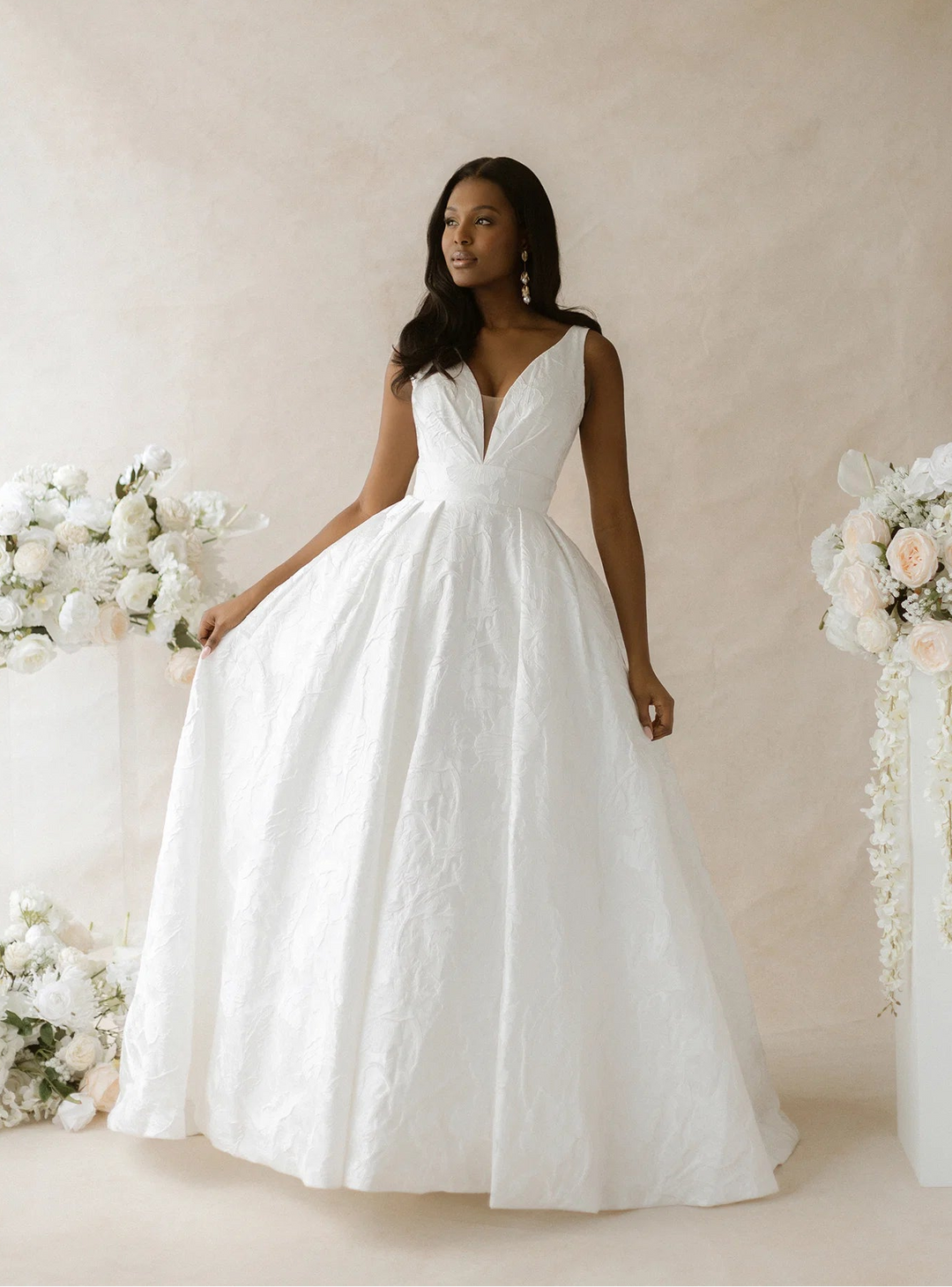 front of abella parrish e565 ivory jacquard a-line wedding dress with a V neckline and floral print