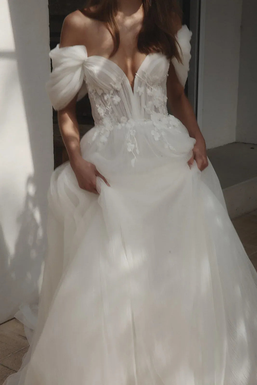 close up of alena leena clivia ivory tulle a-line wedding dress showing the sweetheart neckline and detachable straps