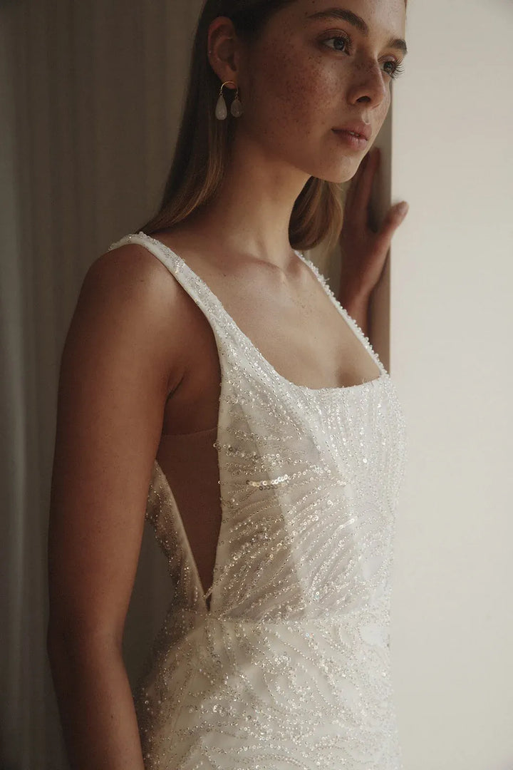 Woman wearing a sparkling wedding dress indoors.