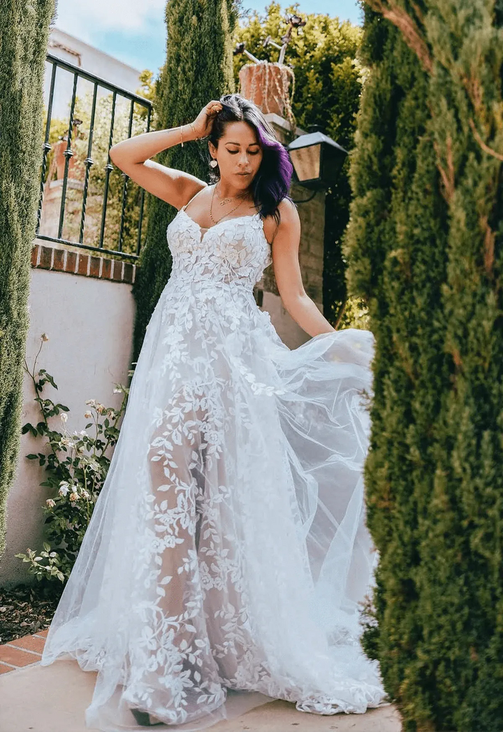 front of all who wander haven champagne tulle a-line wedding dress with a v neckline and sheer floral skirt