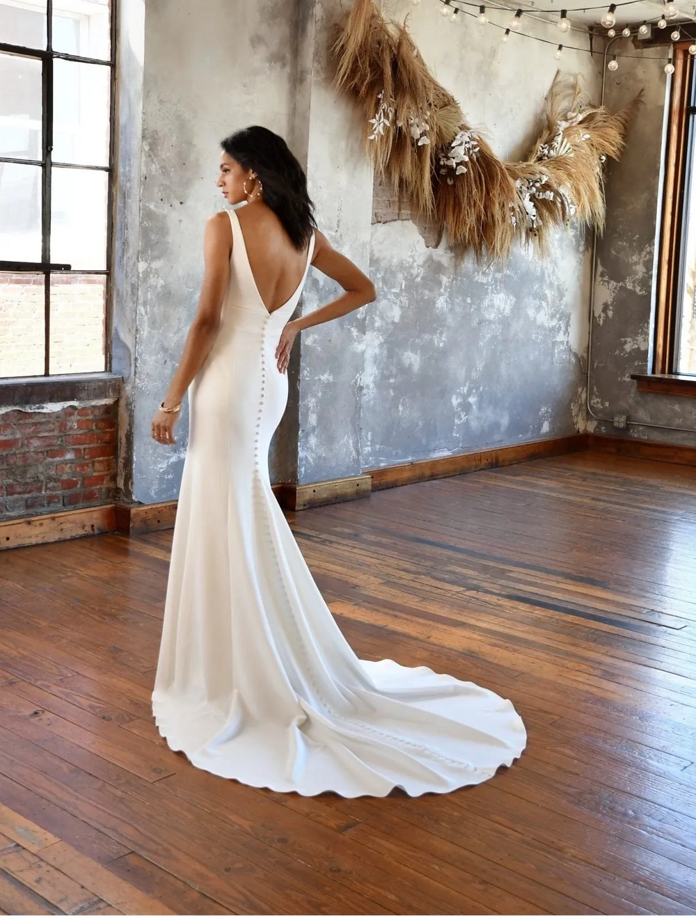 all who wander iona crepe fit and flare wedding dress showing back of gown, with v back and chapel length train