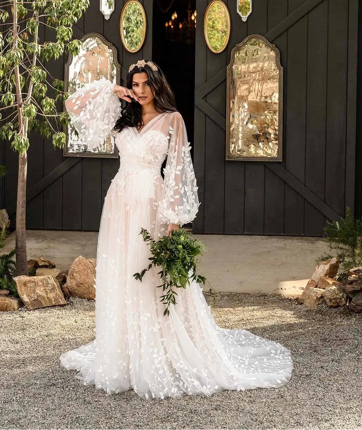 Woman in a white wedding dress standing in front of a dark wooden barn with decorative mirrors and antlers.