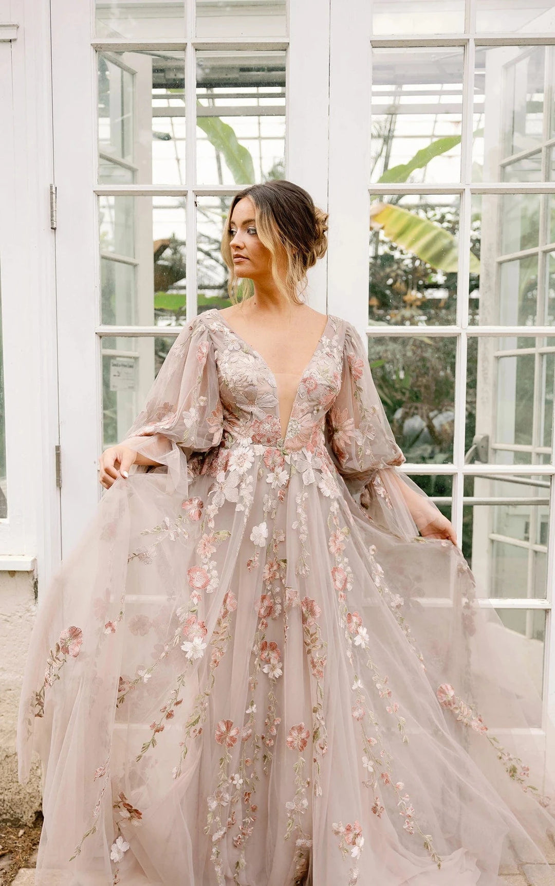 front of all who wander saylor tulle multicolored a-line wedding dress with colorful floral details throughout, and long sleeves
