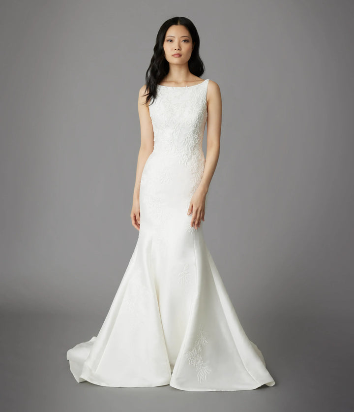 Woman wearing a white wedding dress against a gray background