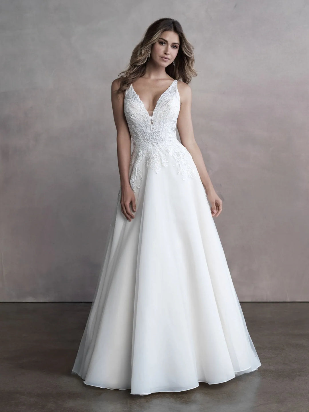 White wedding dress with lace detailing on a plain background