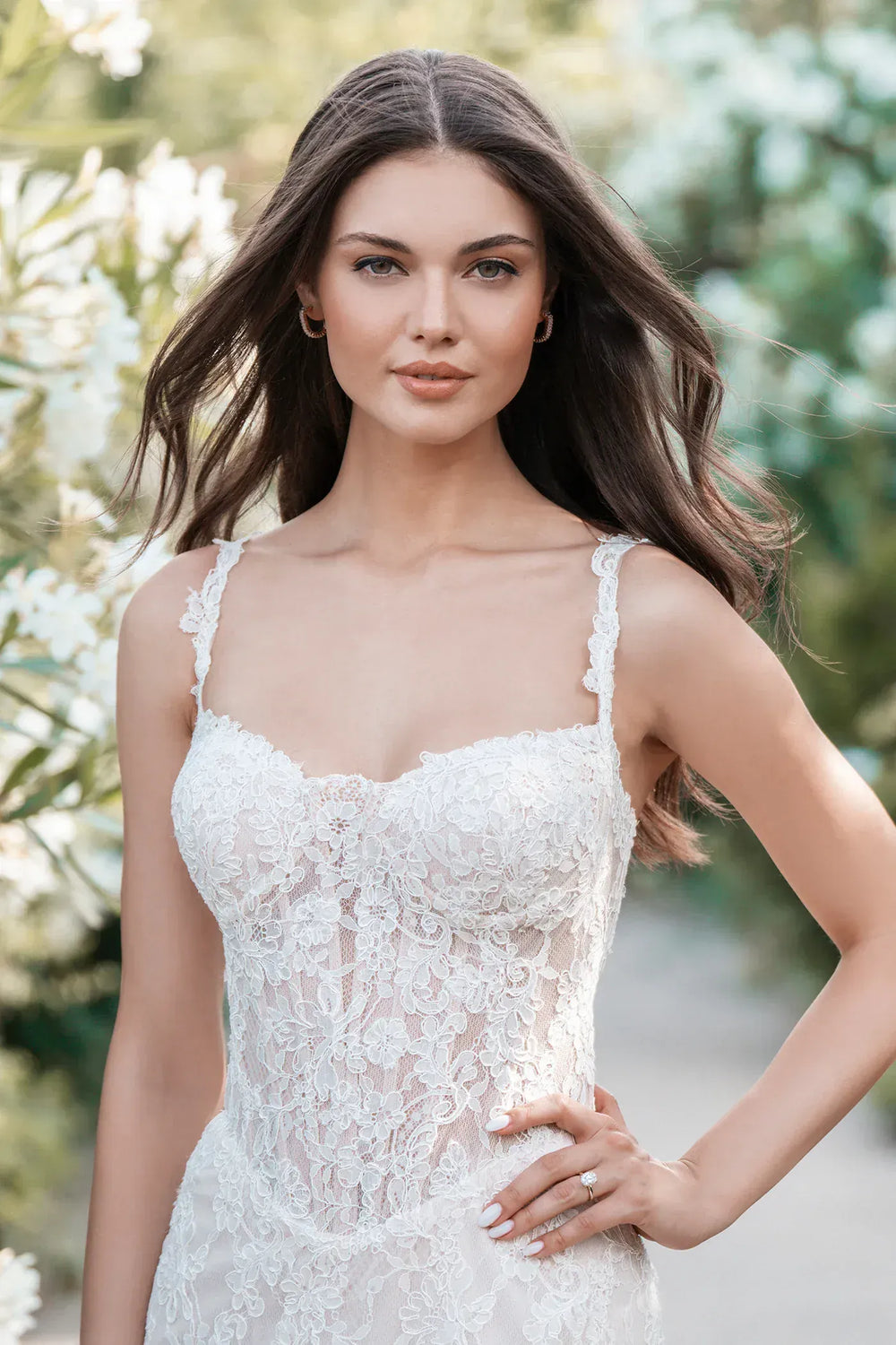 Woman wearing a white lace dress with a blurred natural background