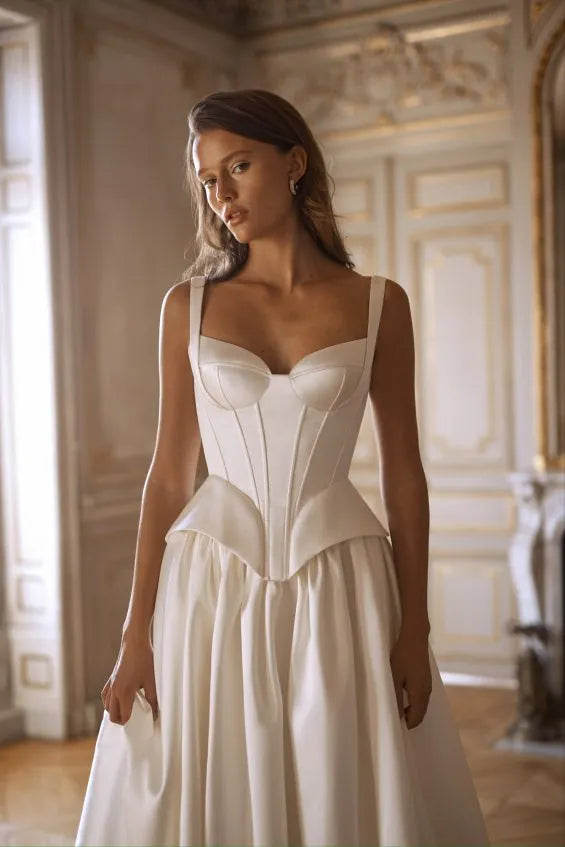 close up of alon livne charlotte ivory mikado bridal set with a full skirt and corset top, with a peplum accent