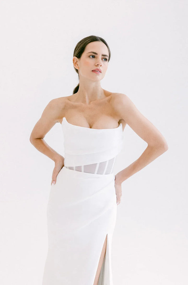 close up of alyssa kristin aria crepe ivory fitted wedding dress with a cat eye bodice and skirt slit