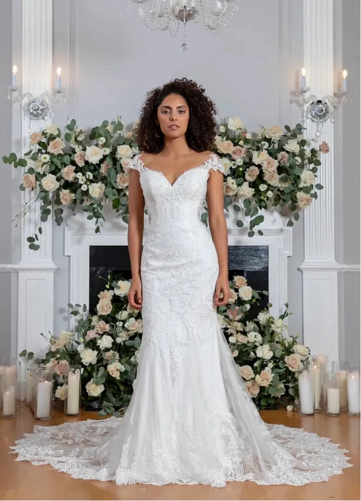full front of flores by angel rivera ivory lace fitted wedding dress with cap sleeves and a sheer lace train