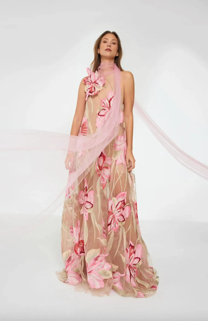 Woman wearing a floral dress with a pink scarf on a white background