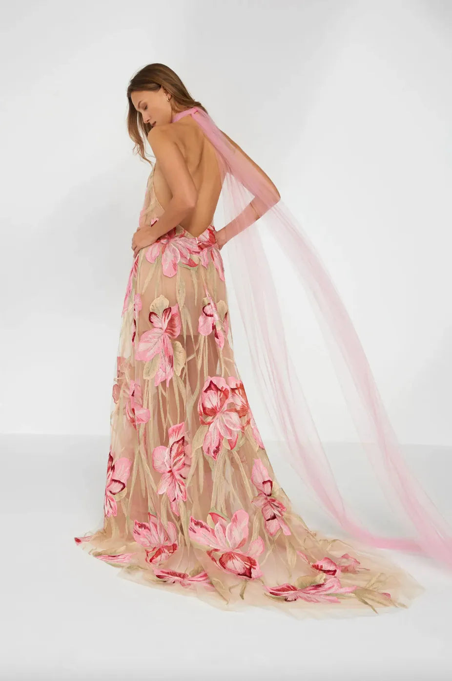 Woman wearing a floral dress with pink flowers on a white background