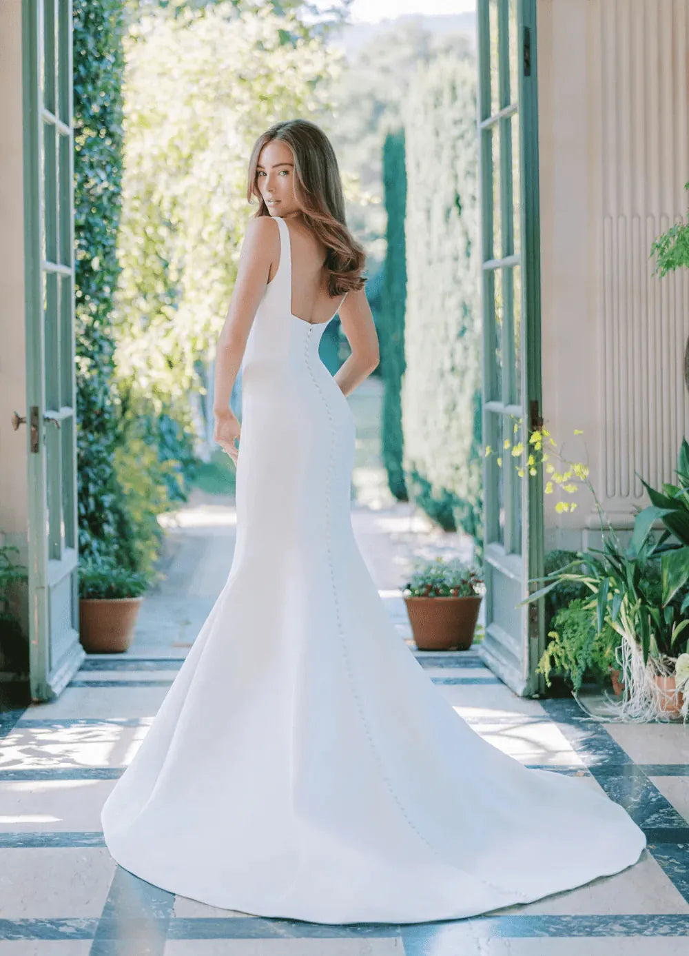 Woman in a white wedding dress standing in a garden setting