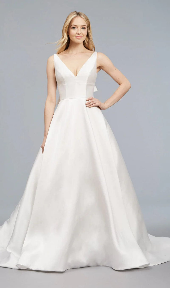 Woman wearing a white wedding dress against a gray background