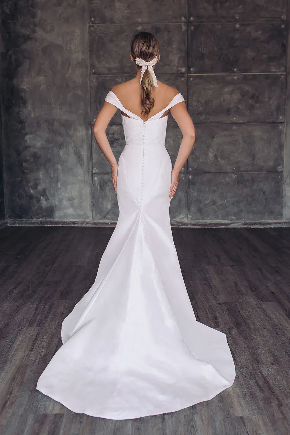 Woman wearing a white wedding dress with a plain background
