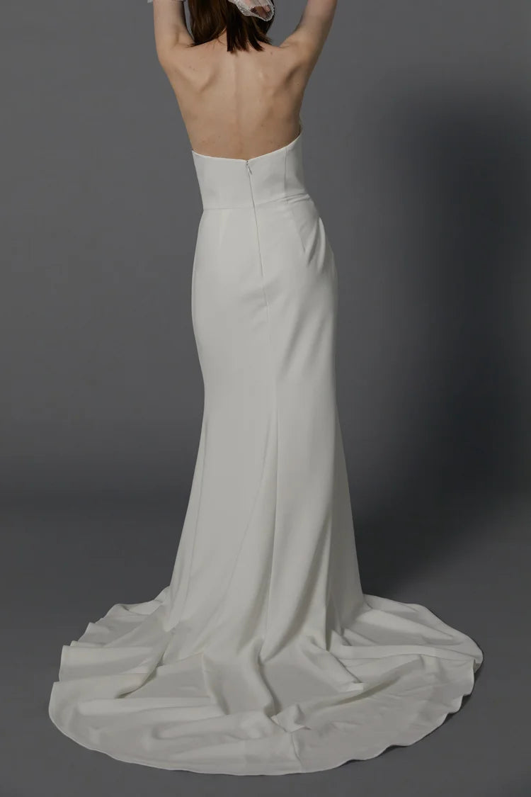 full back of besa bridal andre ivory crepe fitted wedding dress featuring an open back and chapel length train