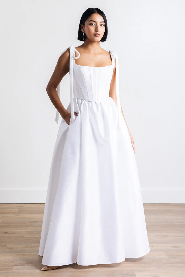 Woman wearing a white dress against a plain background