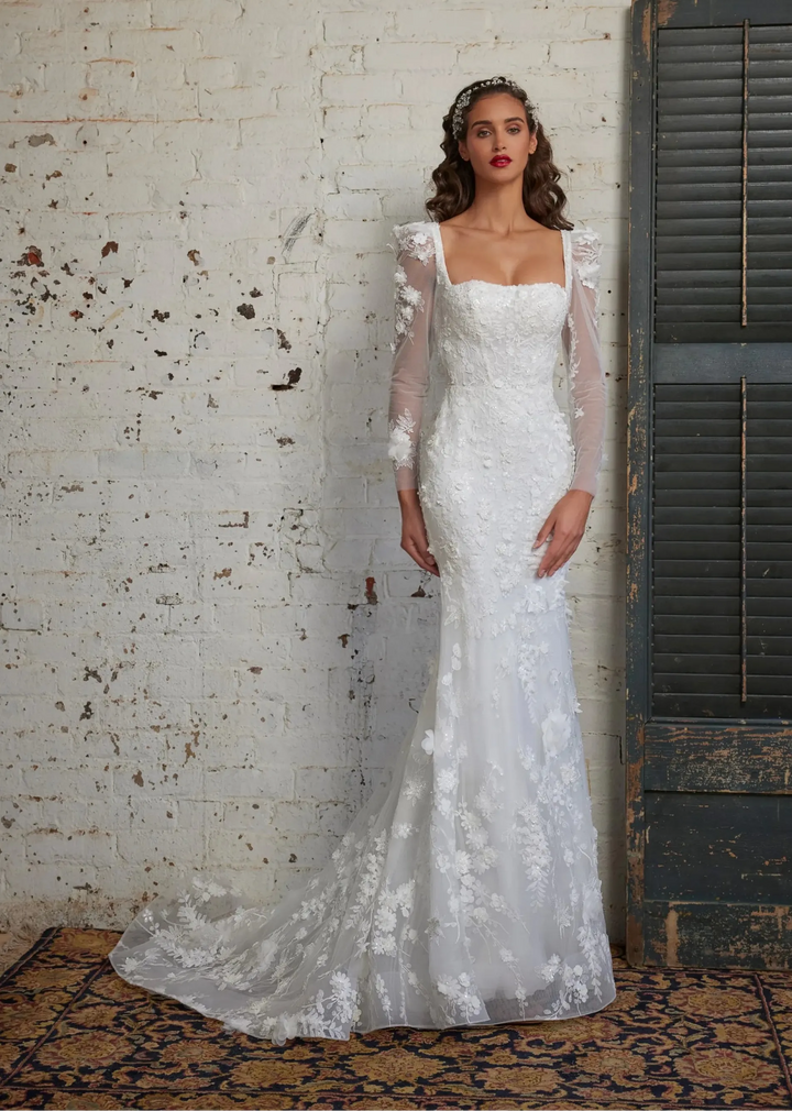 front of calla blanche ivory lace fit and flare wedding dress with a square neckline, long sleeves, and floral laces