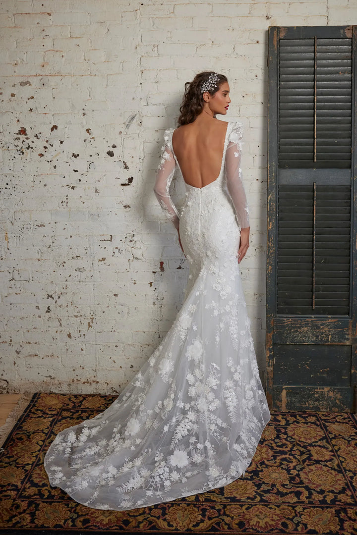 back of calla blanche ivory lace fit and flare wedding dress with an open back and short train that highlights the floral details
