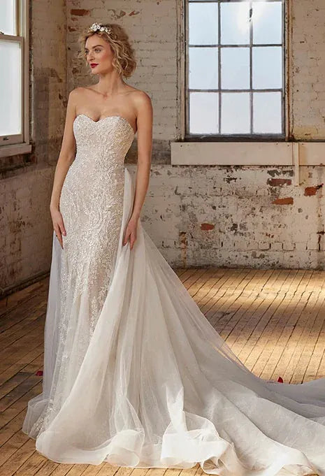 front of calla blanche artemis nude colored lace fitted wedding dress with a strapless sweetheart neckline. pictured with the matching overskirt, which is not included.