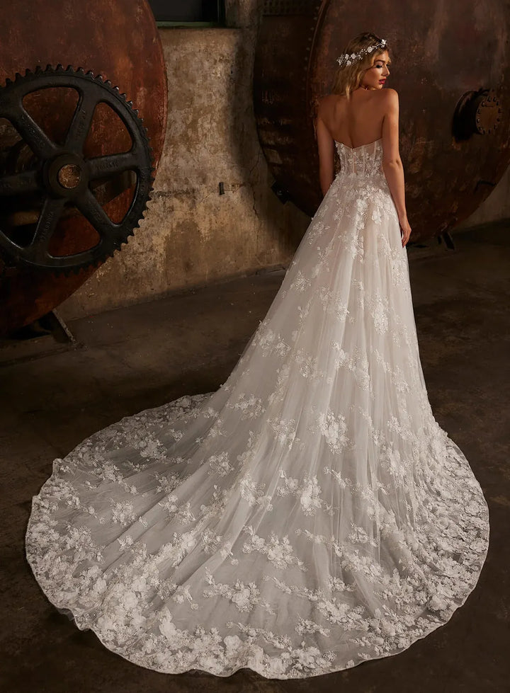 full back of calla blanche nude tulle a-line wedding dress with floral laces throughout and a circle train