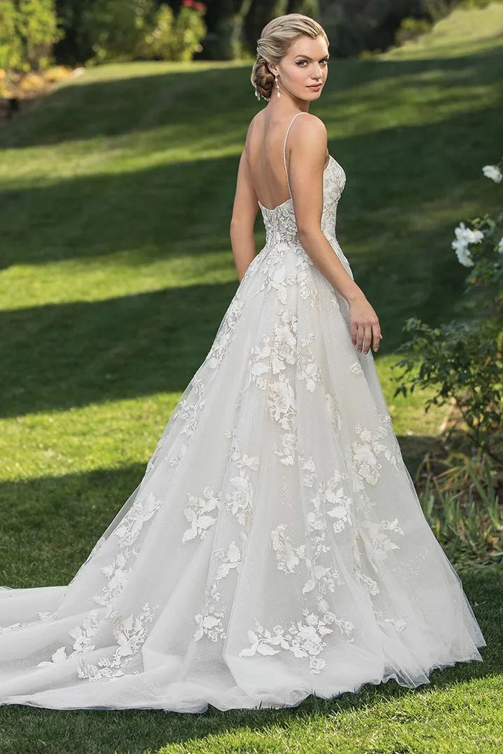 Woman in a white wedding dress standing on grass with a blurred background