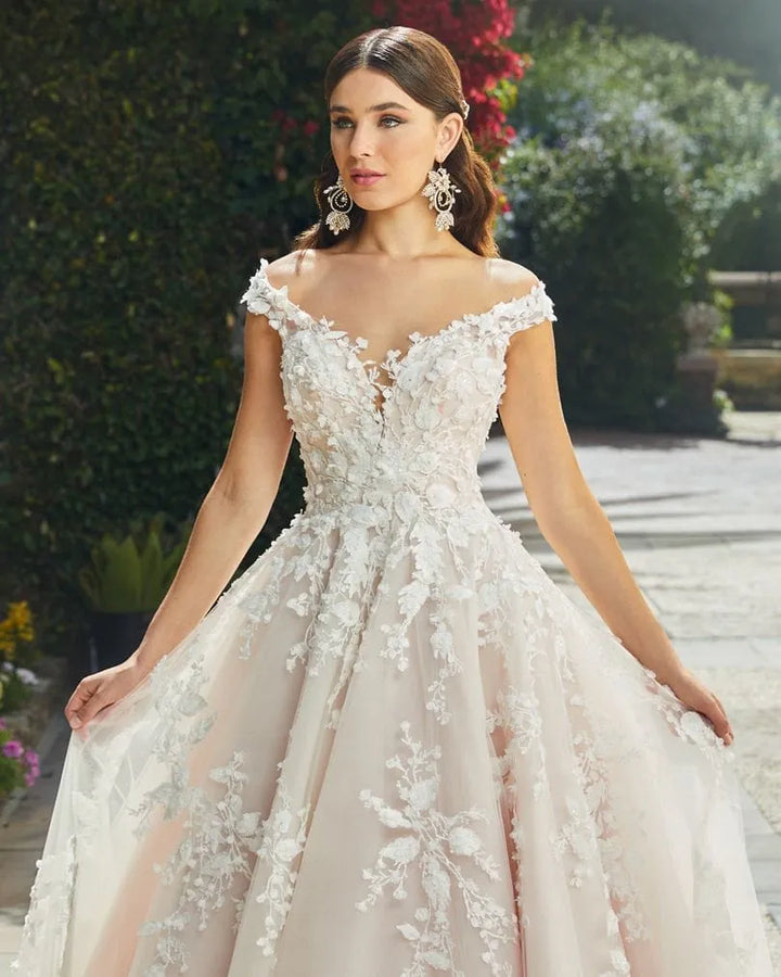 close up of casablanca 2406 blush tulle ball gown wedding dress with lace appliques and an off the shoulder neckline