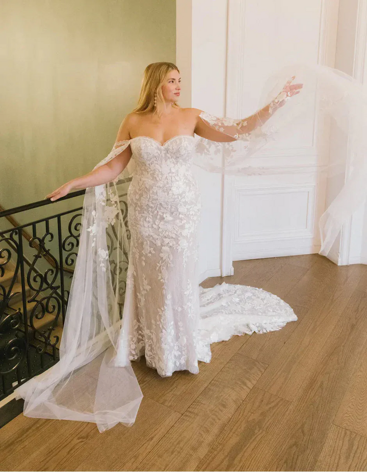 Woman in a white wedding dress standing in an elegant interior setting