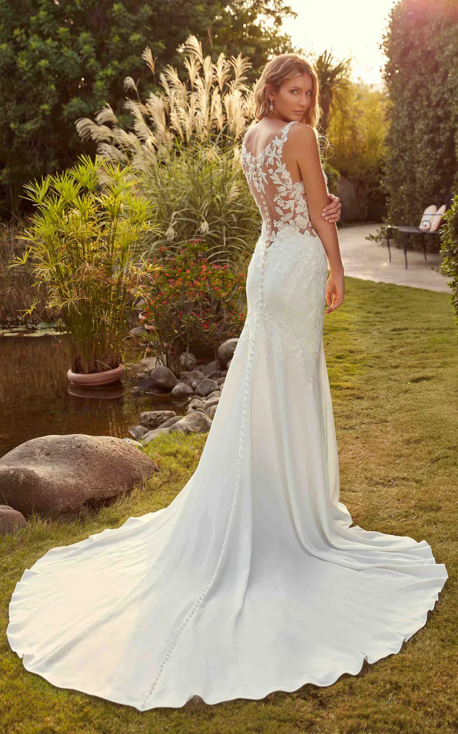 full back of eddy k bailey ivory crepe fitted wedding dress with scattered lace appliques and a sheer back, with a chapel length train