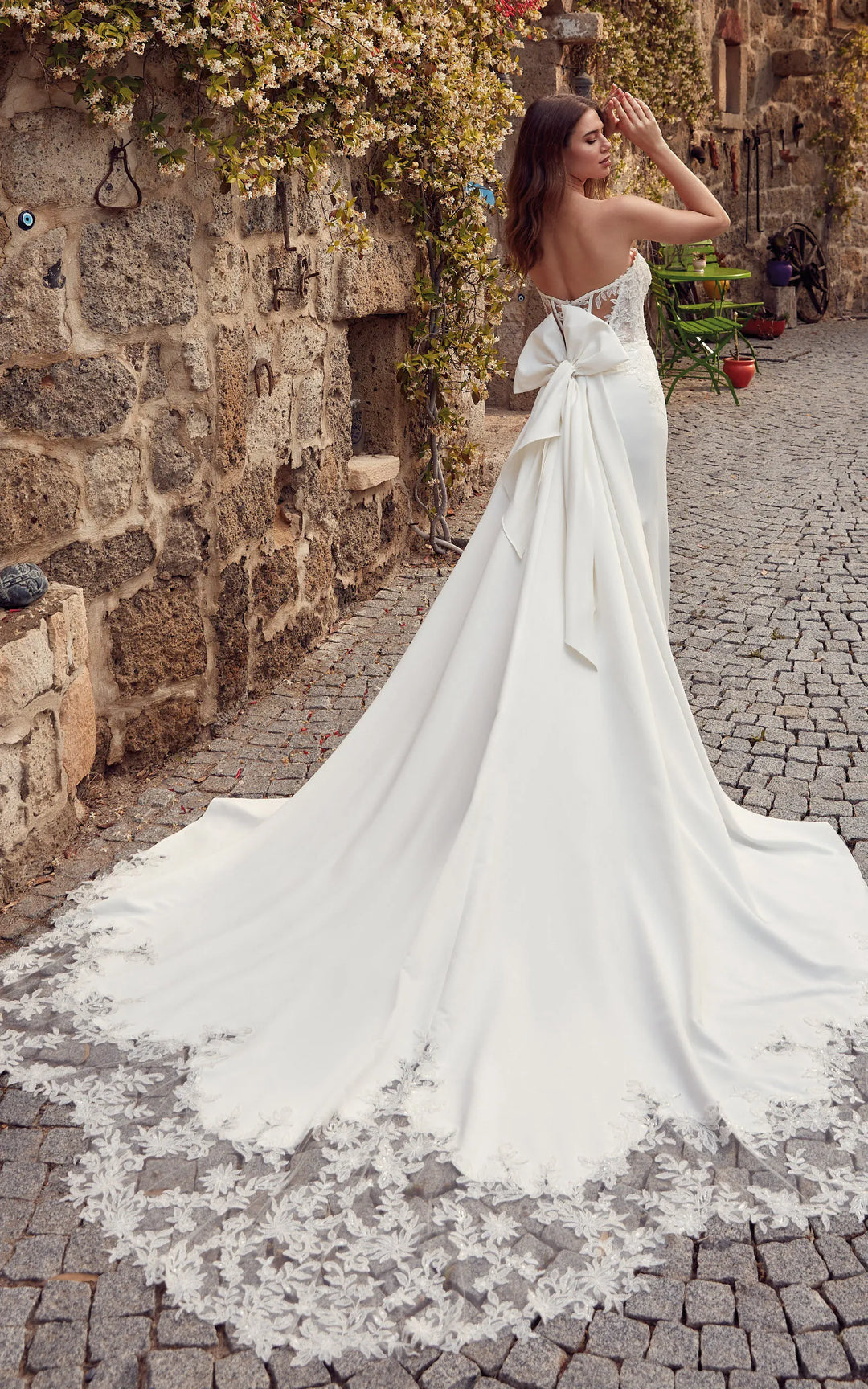 full back of eddy k marissa ivory satin sheath wedding dress with a matching train accents with lace and a bow