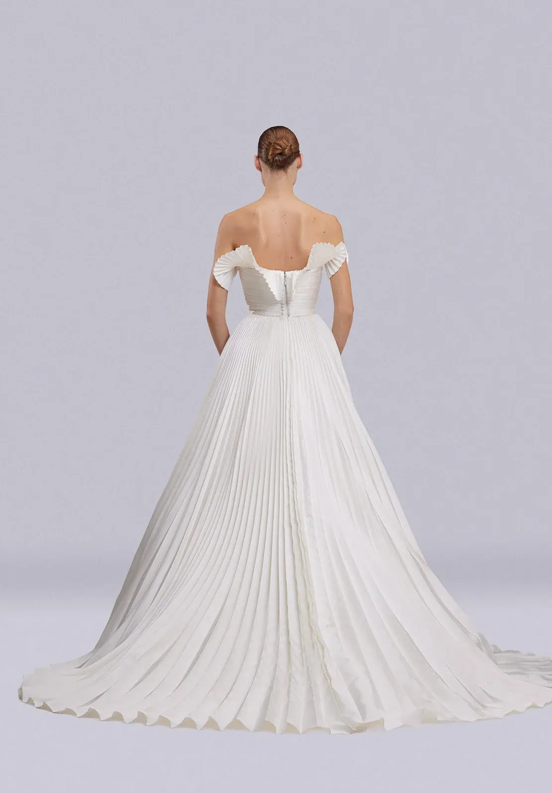 White wedding dress with a long train on a plain background