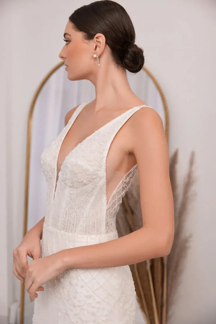 Woman wearing a white lace dress with a plain background