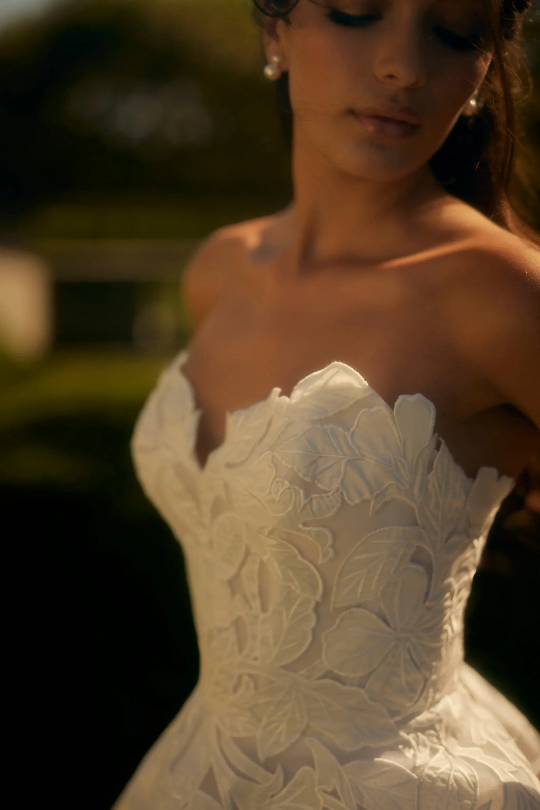 Close-up of a strapless wedding dress with floral lace details.