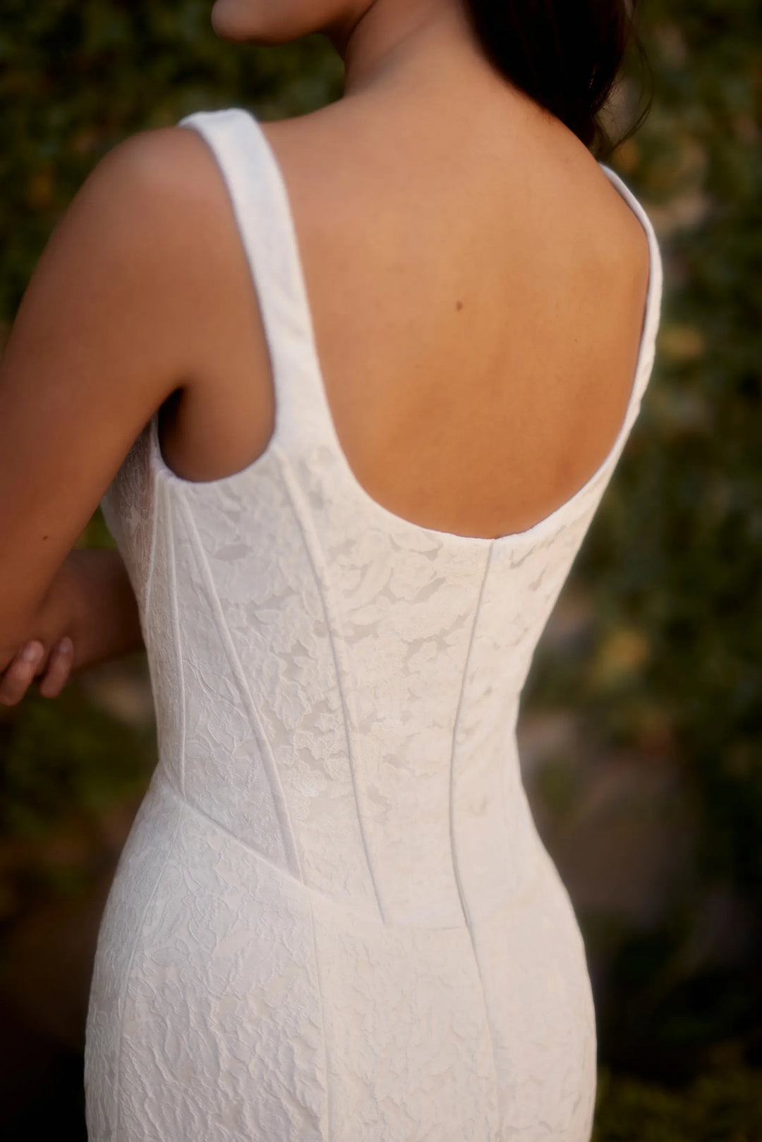 White lace dress with a blurred natural background