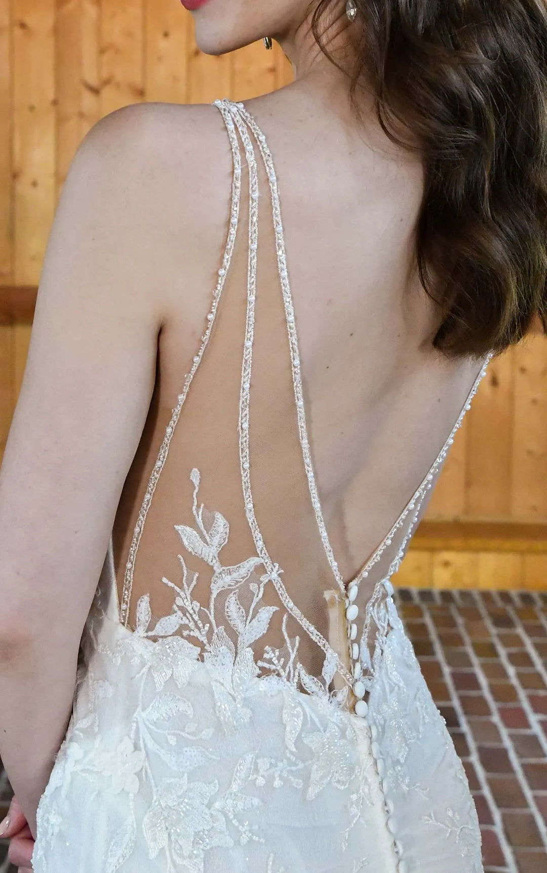close up of essense d3657 ivory lace fitted wedding dress showing the sheer back with beading