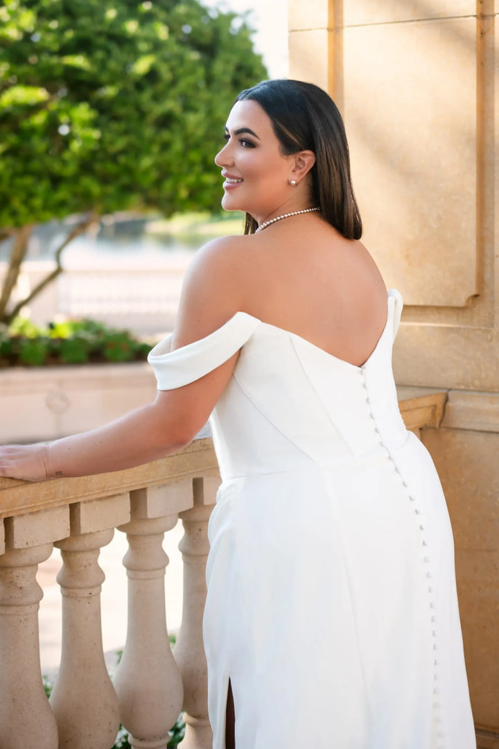close up of the back of essense d3864 ivory crepe fitted wedding dress featuring an off the shoulder neckline