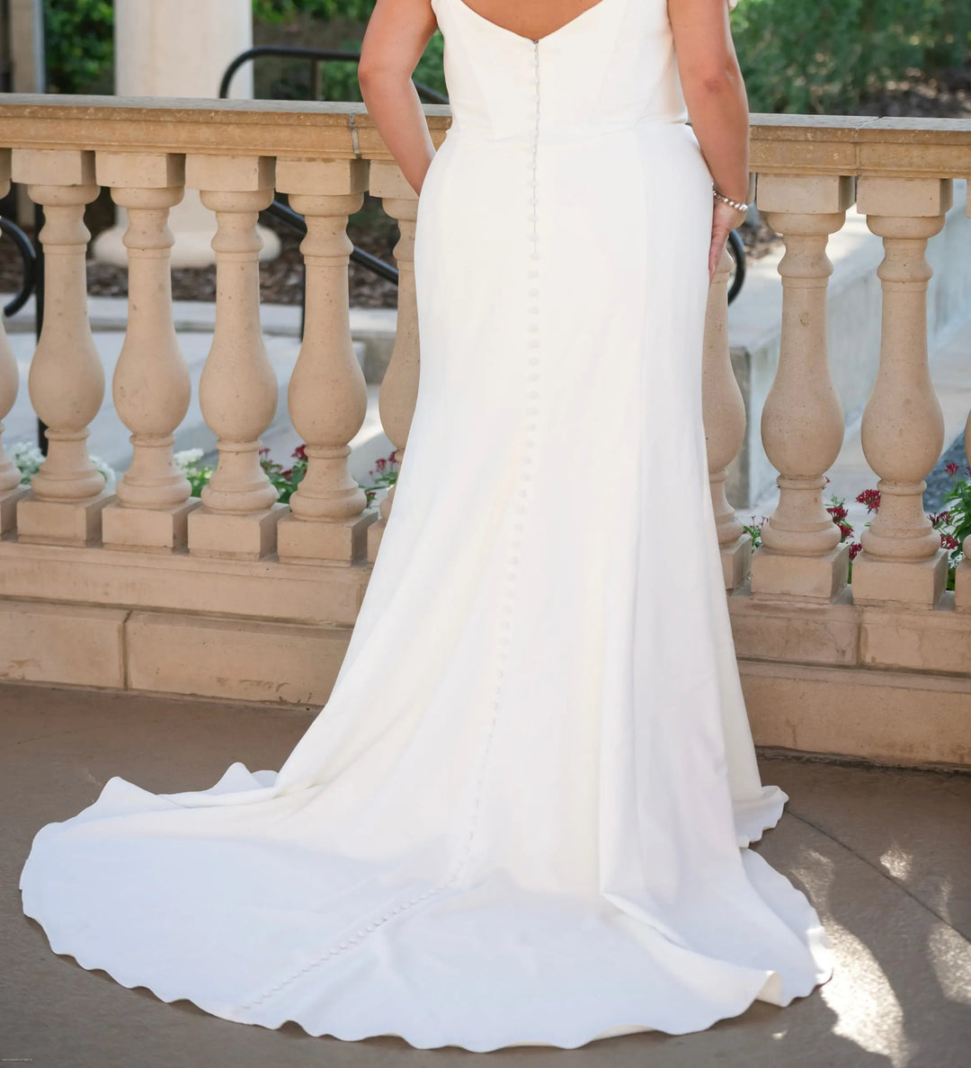 close up of the back of essense d3864 ivory crepe fitted wedding dress featuring buttons down the back