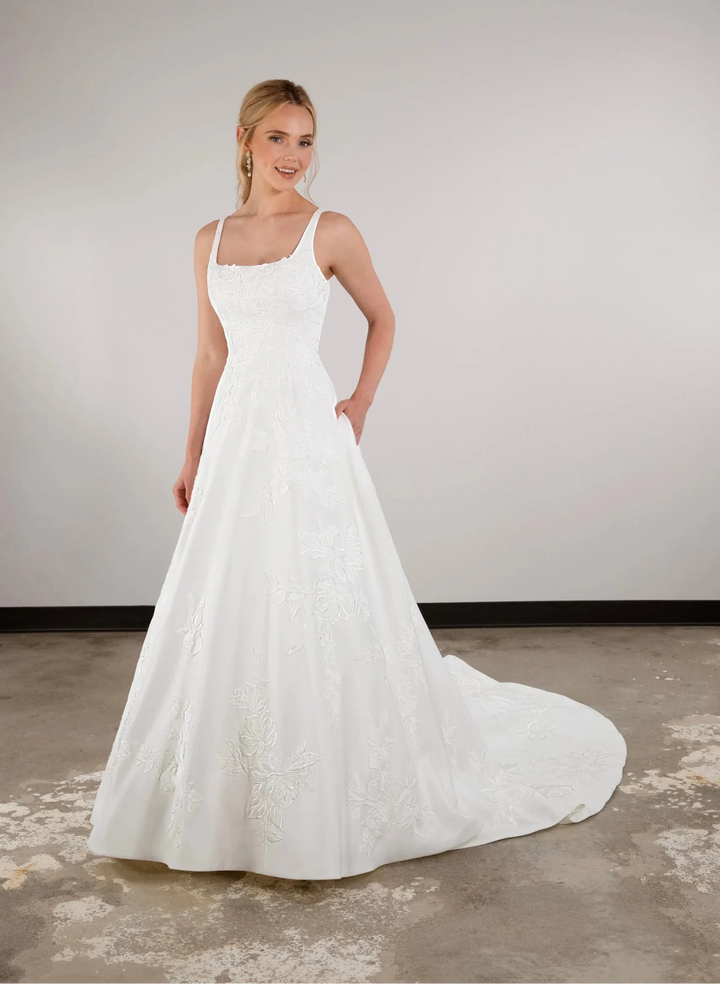 full front of essense of auatralia d3965 ivory satin a-line wedding dress with a square neckline and floral details on the bodice