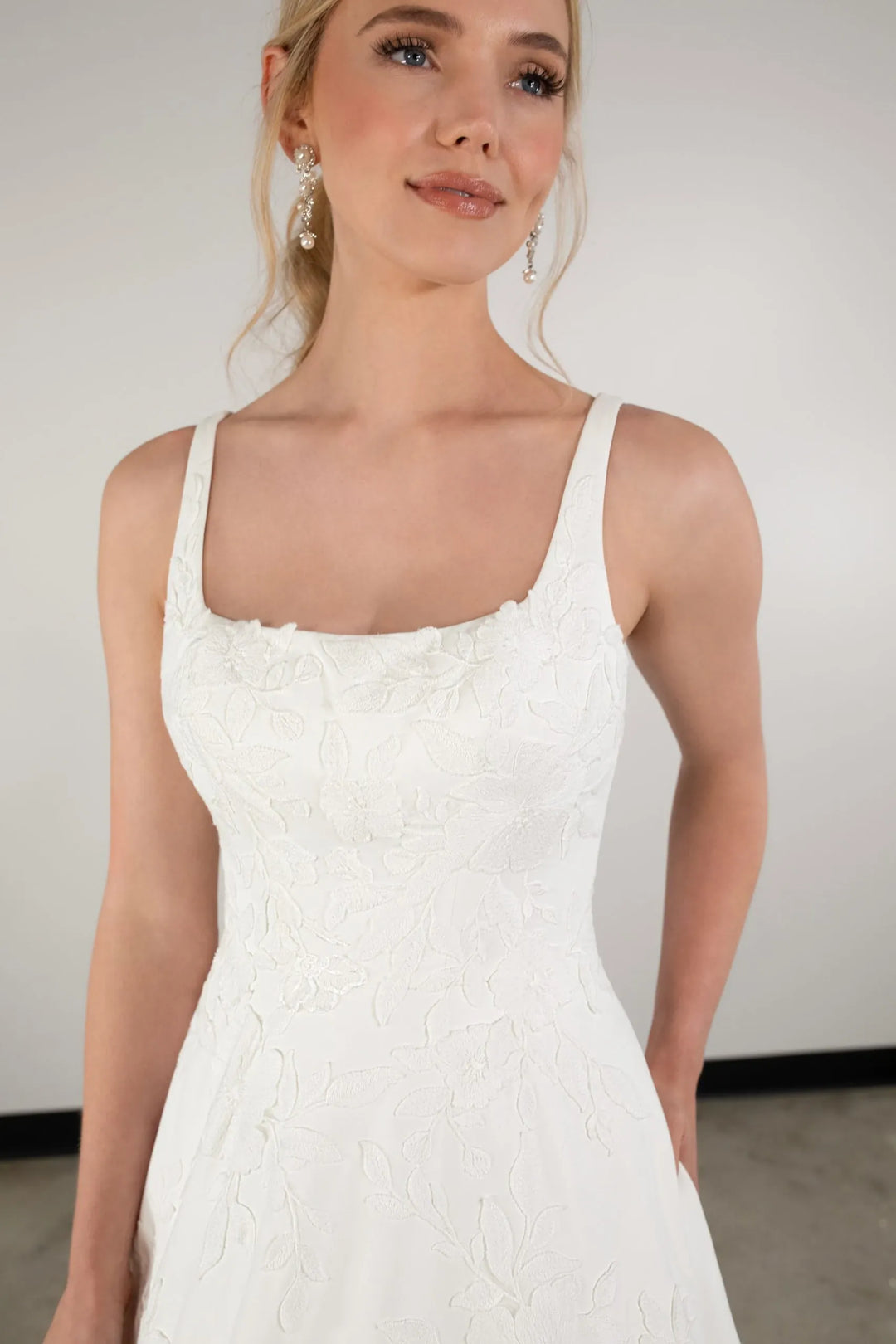 close up of essense of auatralia d3965 ivory satin a-line wedding dress showing the square neckline and floral details