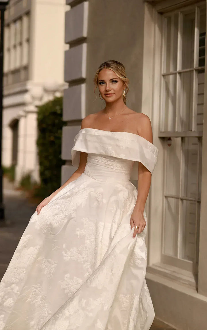 close up of essense of australia d3971 ivory jacquard ball gown showing the matching off the shoulder neckline