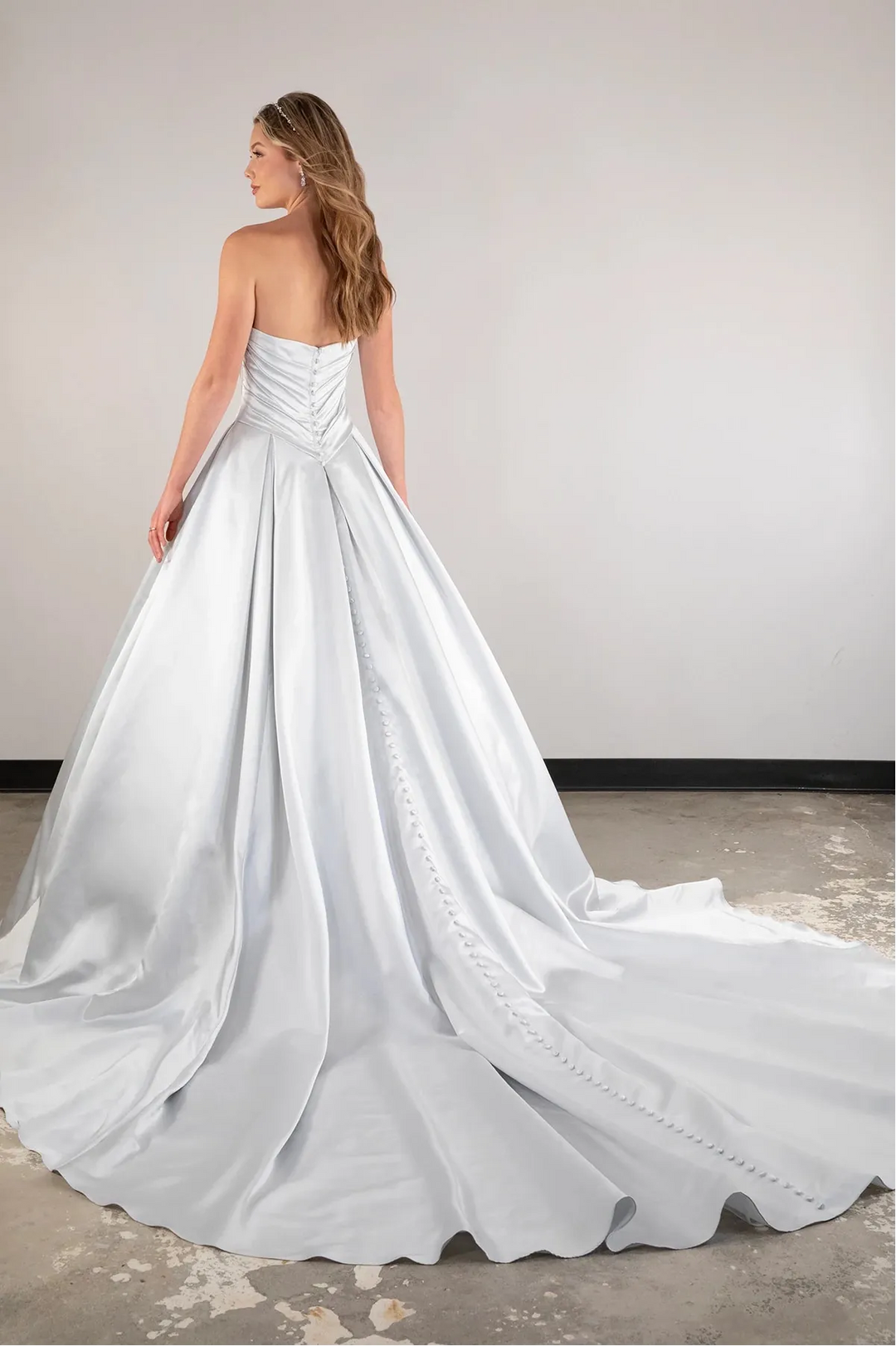 Woman wearing a strapless white wedding dress with a flowing train.