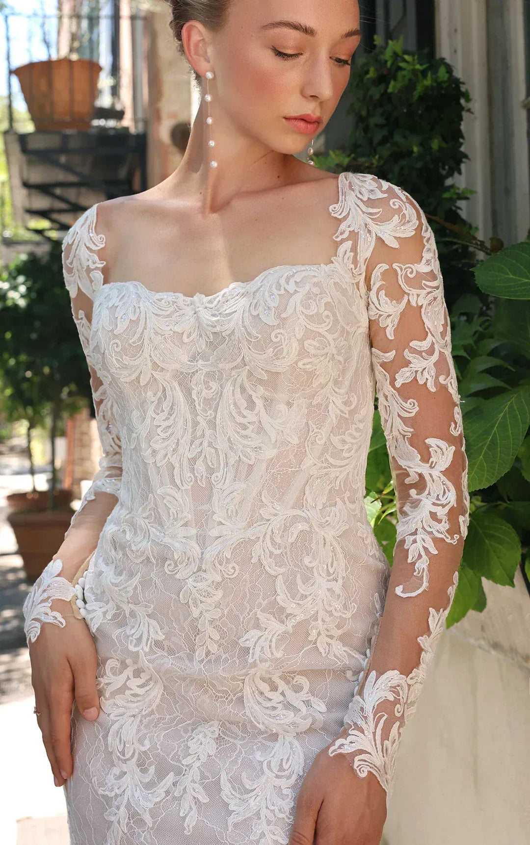 close up of essense d4172 ivory lace sheath wedding dress with long sleeves and a shaped train