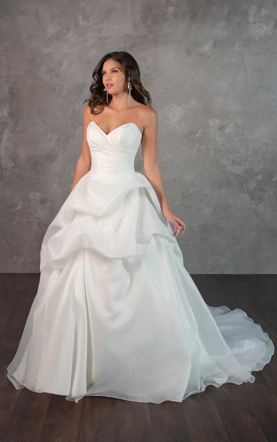 Woman wearing a strapless wedding dress against a gray background