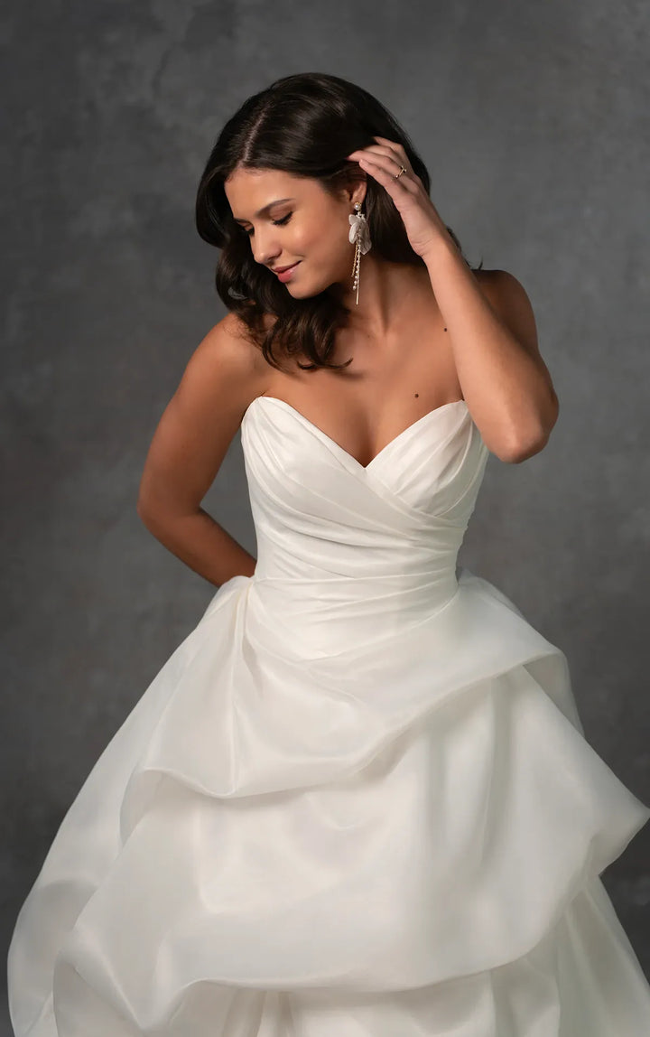 Woman wearing a white wedding dress against a gray background