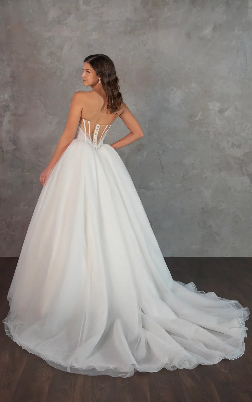 White wedding dress with a corset back on a plain background