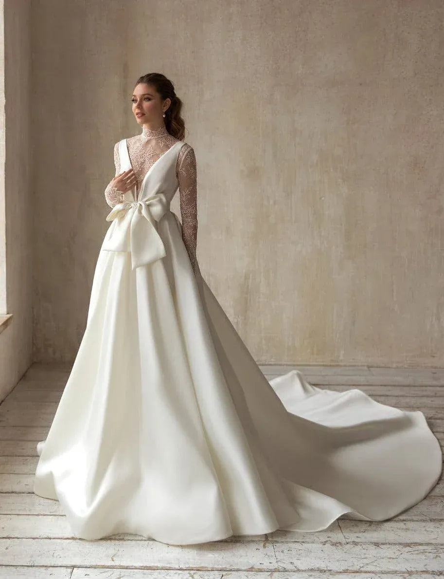 full front of eva lendel magdalena ivory mikado a-line wedding dress with a bow on the bodice and a matching lace long sleeve bodice