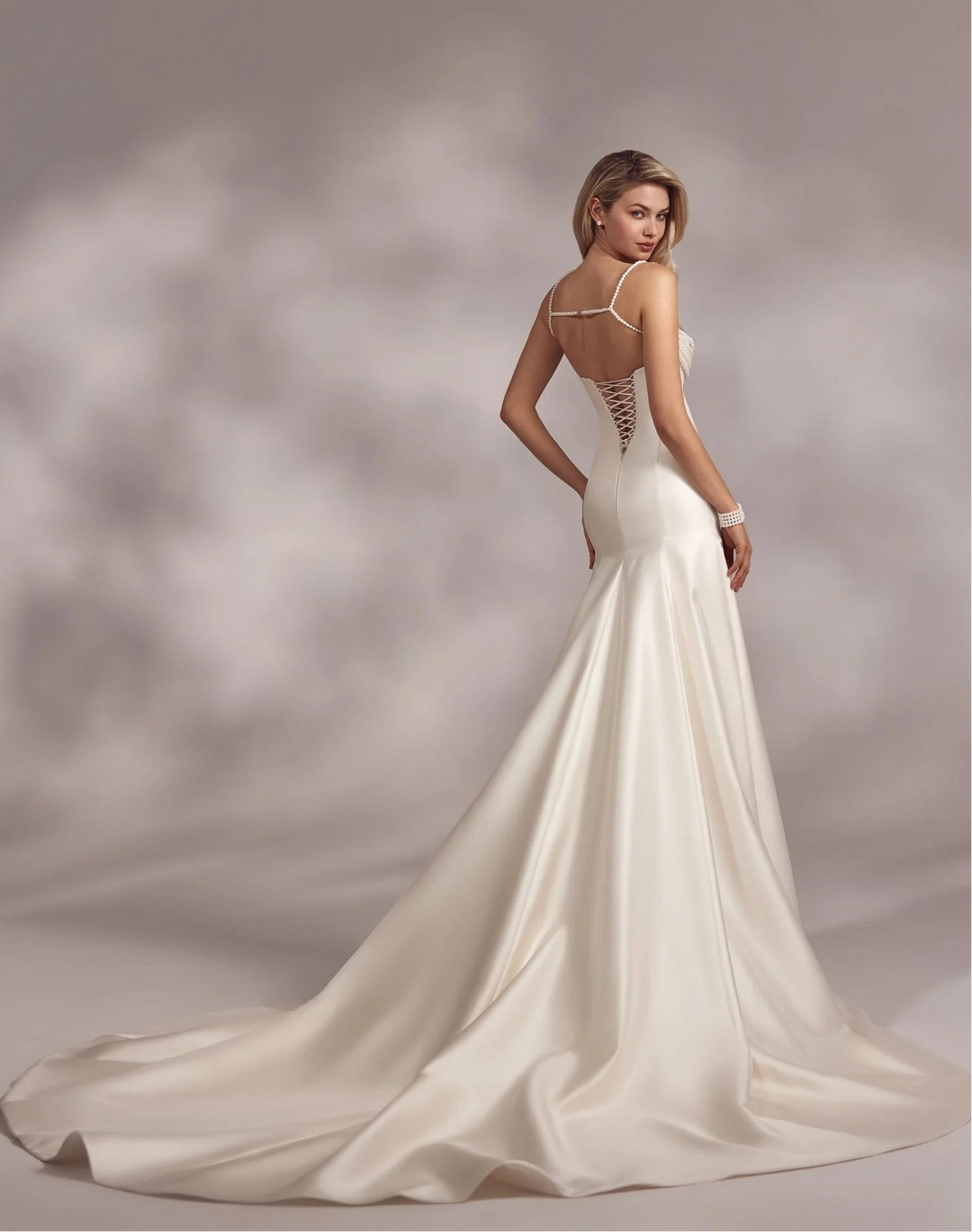 back of eva lendel ora ivory satin fitted wedding dress with beaded details and lace up back, with a chapel length train