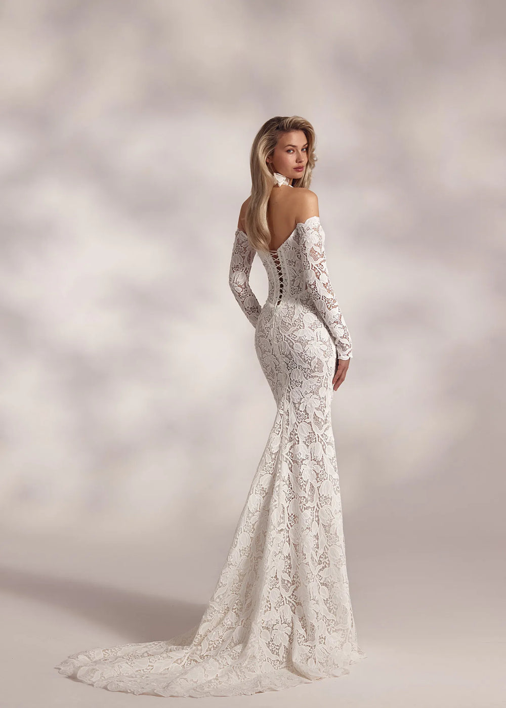 Woman wearing a white lace wedding dress against a soft, blurred background