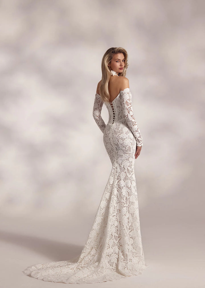 Woman wearing a white lace wedding dress against a soft, blurred background