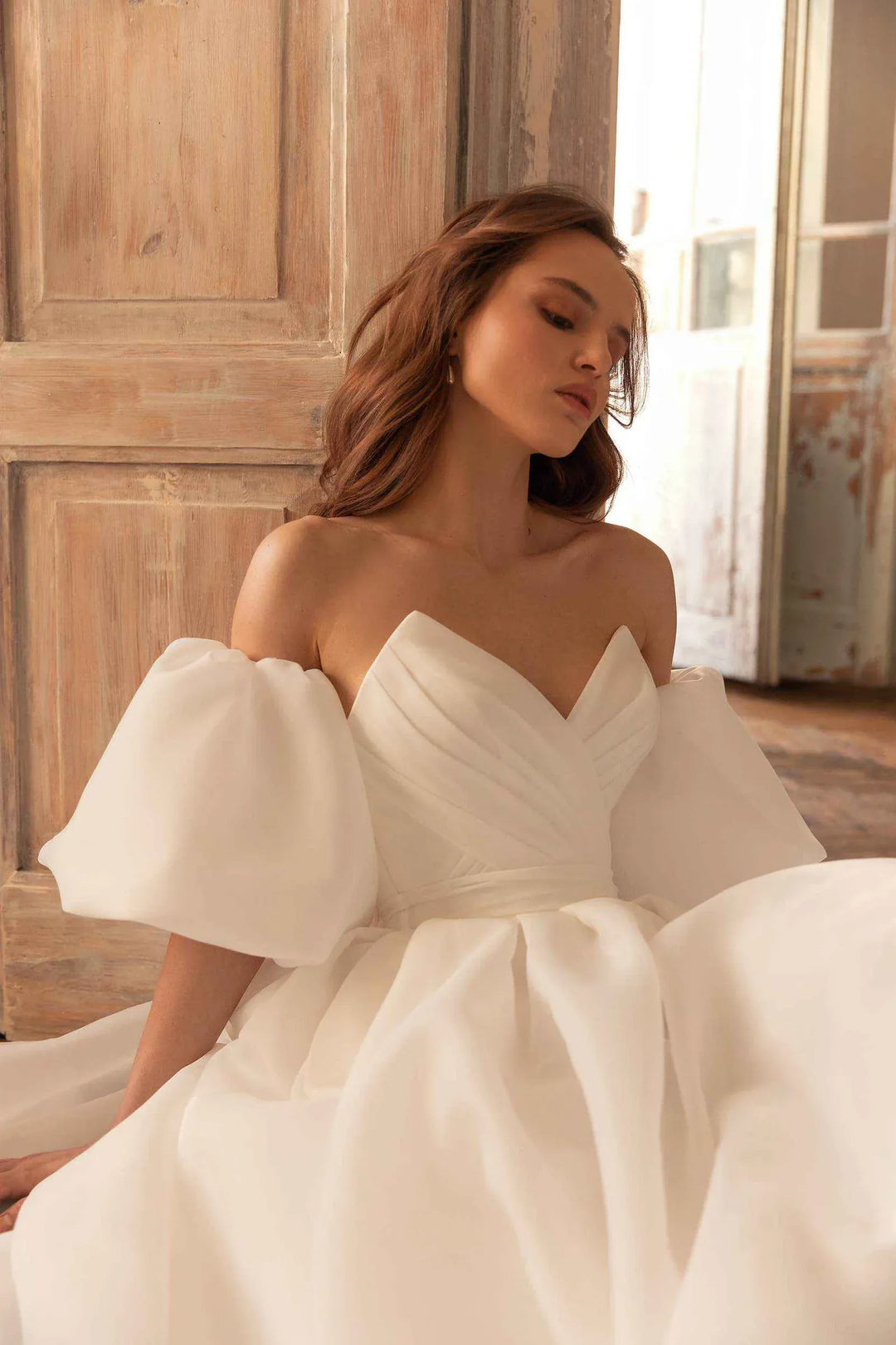 close up of eva lendel samanta ivory organza a-line wedding dress with a strapless v neckline and detached cap sleeves