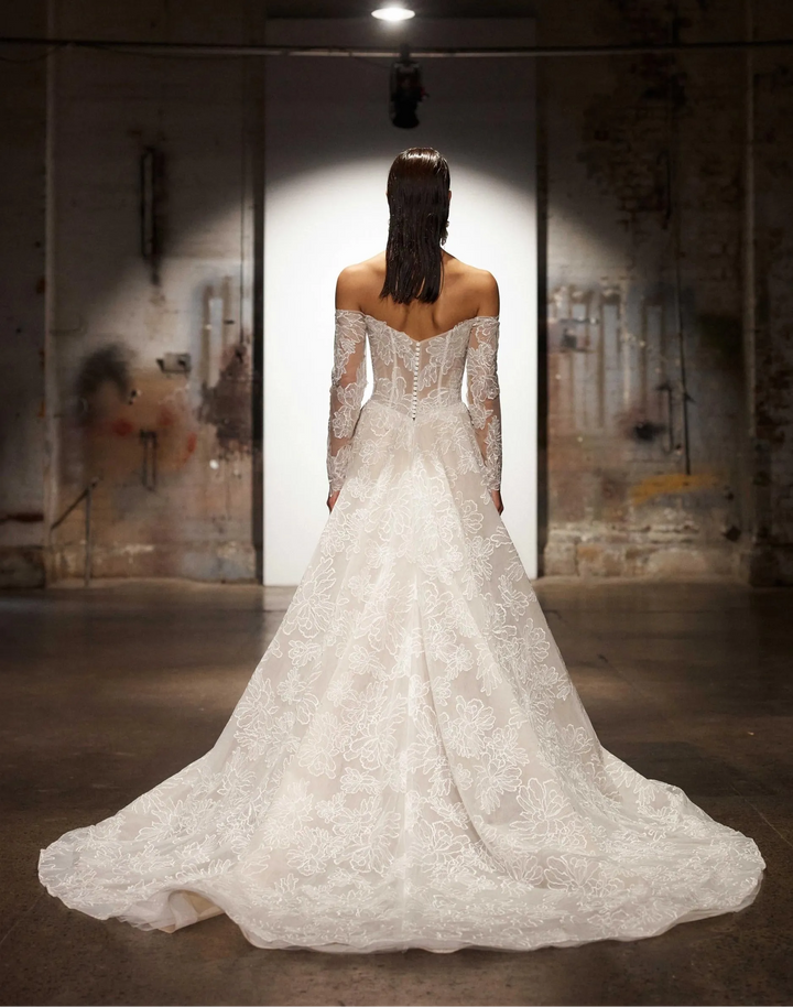 back of evie young chevelle mocha lace a-line wedding dress showing the off the shoulder long sleeve neckline and chapel length train